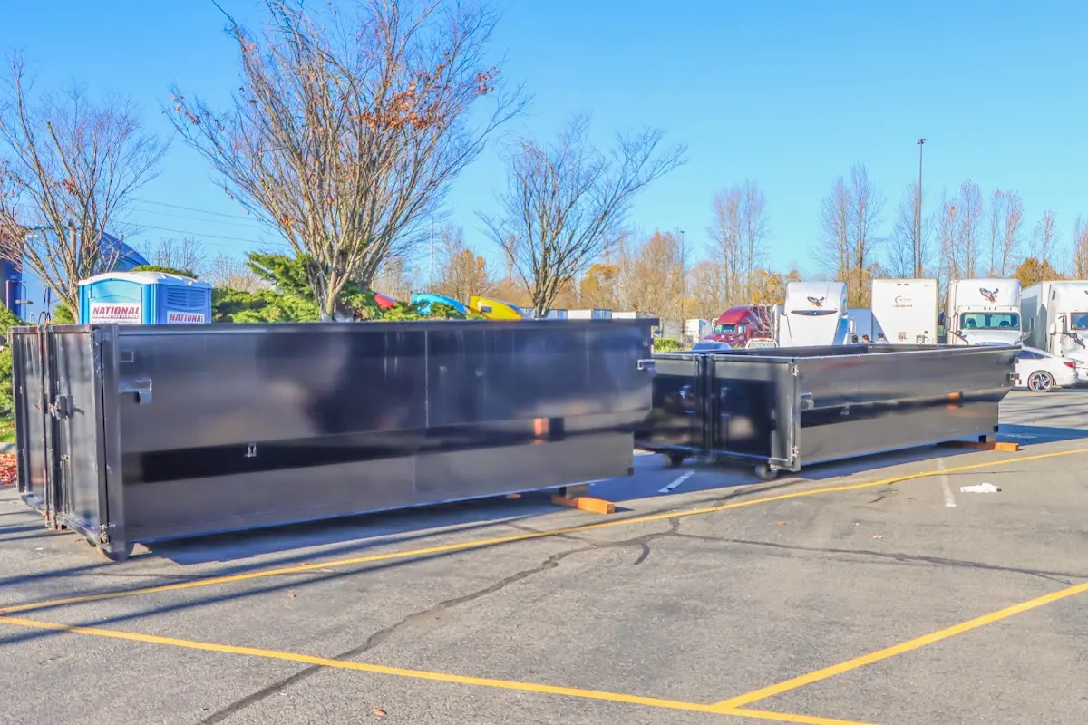 Professional dumpster rental service with roll-off container on residential driveway in Bel Air South